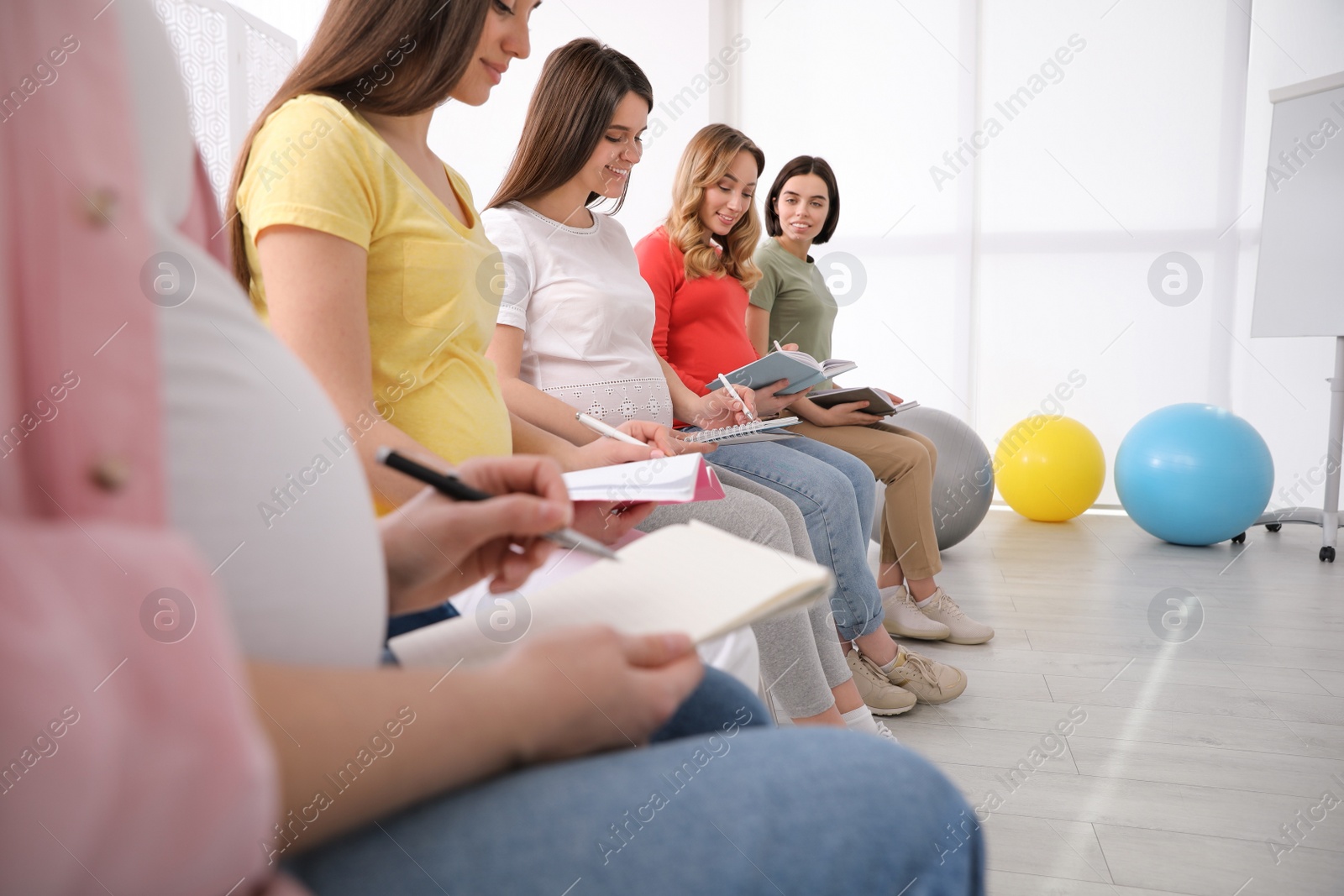 Photo of Group of pregnant women at courses for expectant mothers indoors