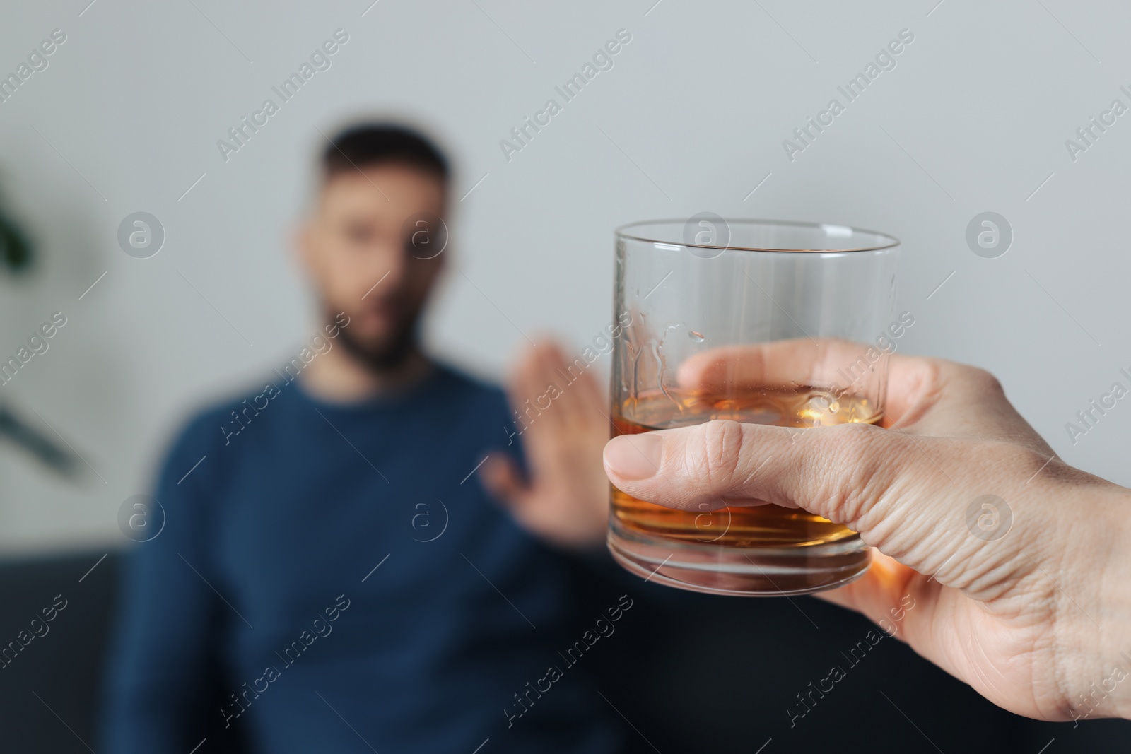 Photo of Man refusing to drink whiskey indoors, closeup. Alcohol addiction treatment