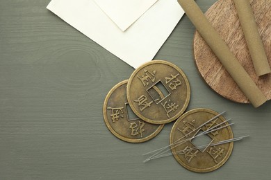 Acupuncture needles, moxa sticks and antique Chinese coins on grey wooden table, flat lay. Space for text