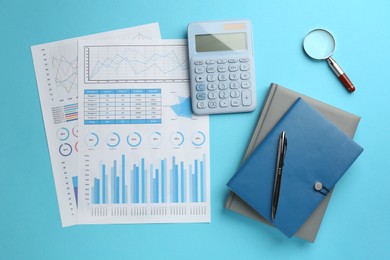 Accounting documents, magnifying glass, calculator and stationery on light blue background, flat lay