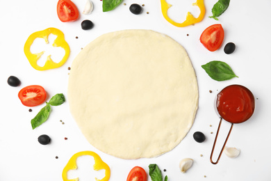 Flat lay composition with dough and fresh ingredients for pizza on white background