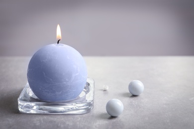 Round wax candle burning on table