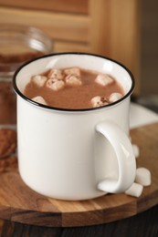 Photo of Cup of aromatic hot chocolate with marshmallows and cocoa powder on table, closeup