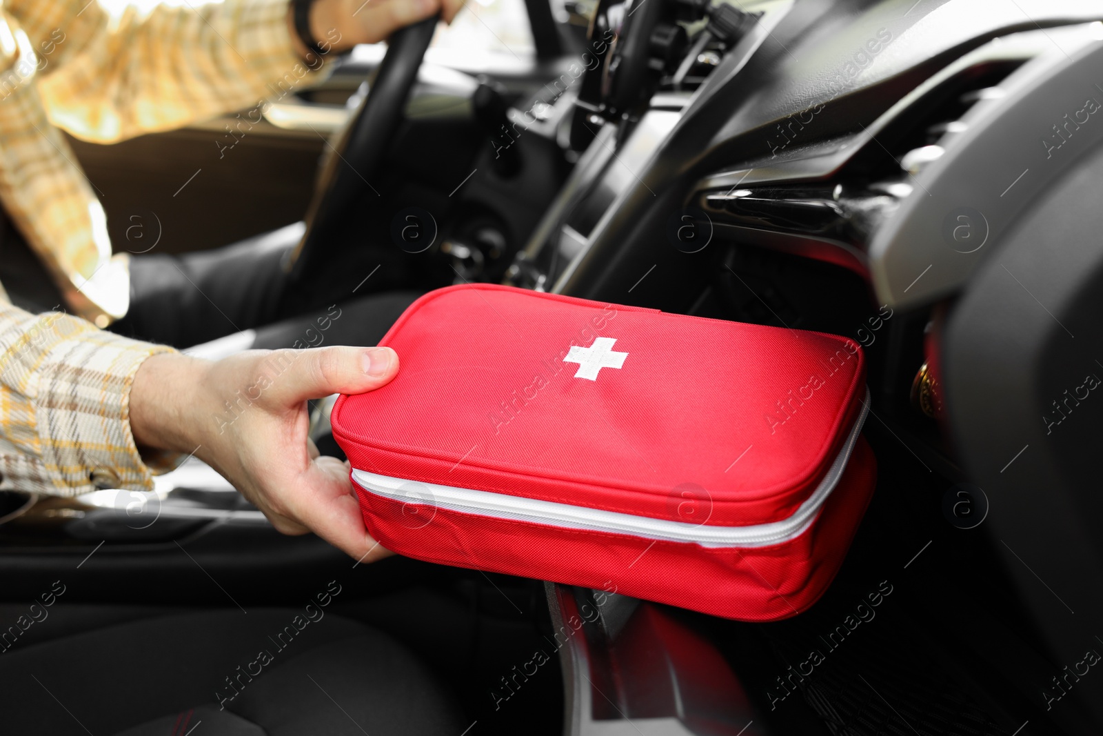 Photo of Man with first aid kit inside car, closeup