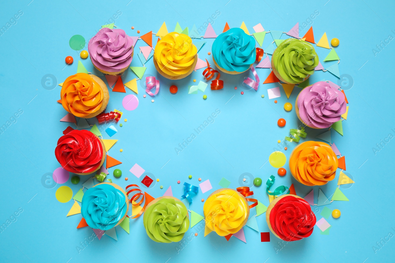 Photo of Colorful birthday cupcakes on light blue background, flat lay. Space for text