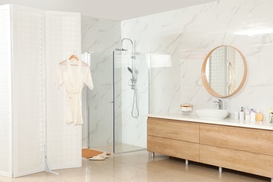 Photo of Modern bathroom interior with shower stall and folding screen