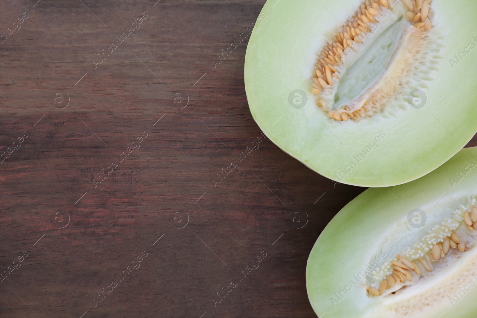 Photo of Cut tasty ripe melon on wooden table, flat lay. Space for text