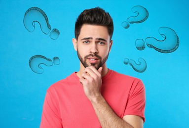 Image of Choice in profession or other areas of life, concept. Making decision, thoughtful young man surrounded by drawn question marks on light blue background