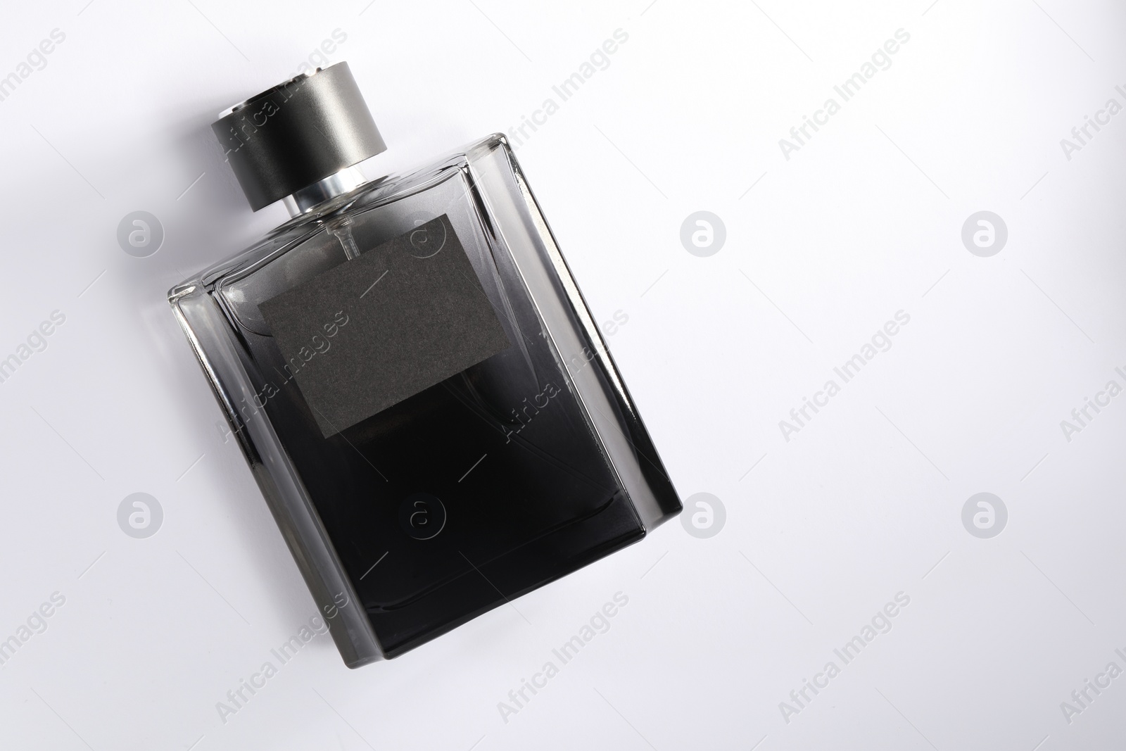 Photo of Luxury men`s perfume in bottle on white background, top view. Space for text