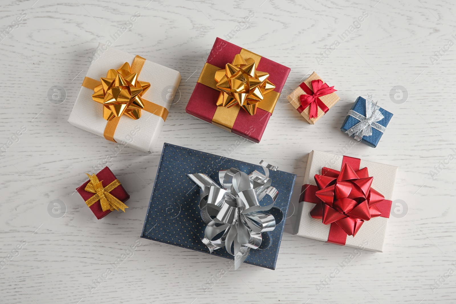 Photo of Flat lay composition with beautiful gift boxes on white wooden table