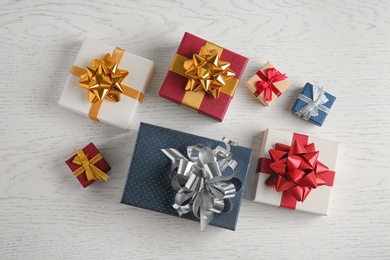 Photo of Flat lay composition with beautiful gift boxes on white wooden table