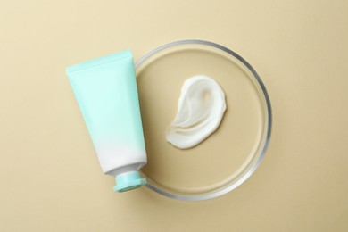 Photo of Petri dish and cosmetic product on beige background, top view