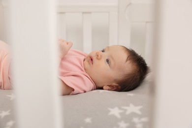 Photo of Getting ready for bed. Cute little baby lying in crib