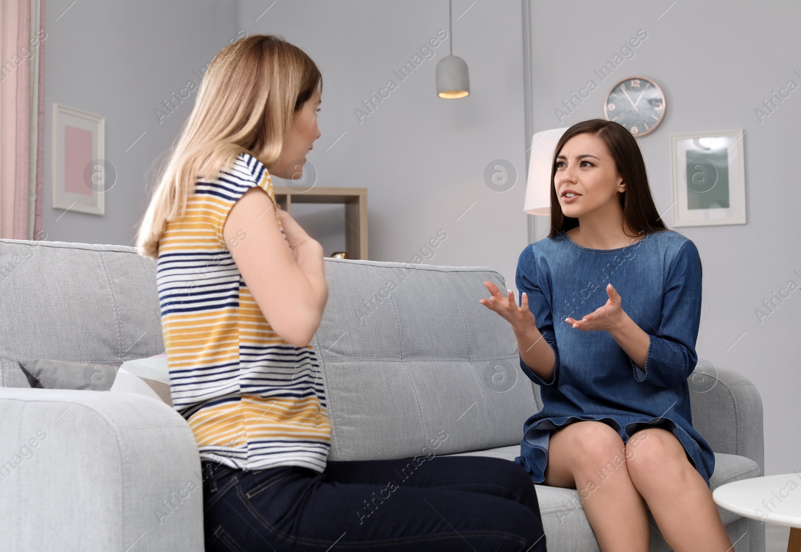 Photo of Friends arguing on sofa at home