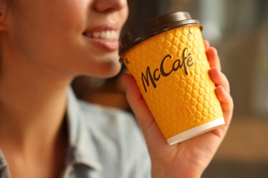 Photo of Lviv, Ukraine - September 26, 2023: Woman with hot McDonald's drink in cafe, closeup