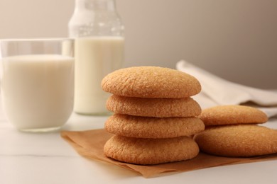 Photo of Delicious Danish butter cookies and milk on white marble table, closeup