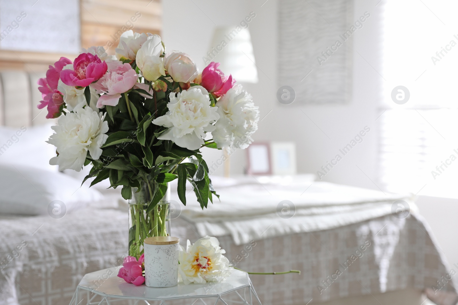 Photo of Beautiful blooming peonies on table in bedroom. Space for text