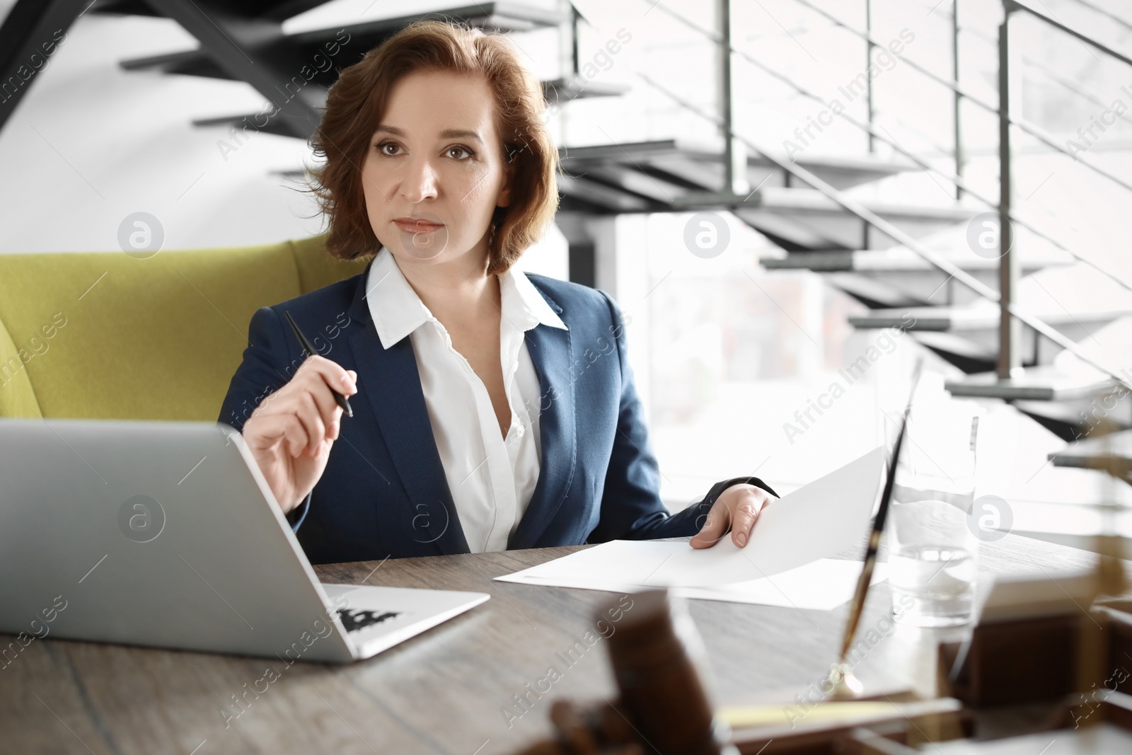 Photo of Female lawyer working at table in office