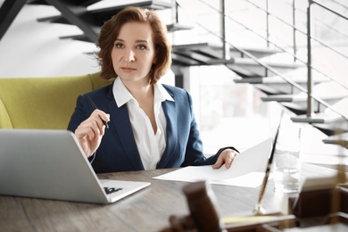 Female lawyer working at table in office