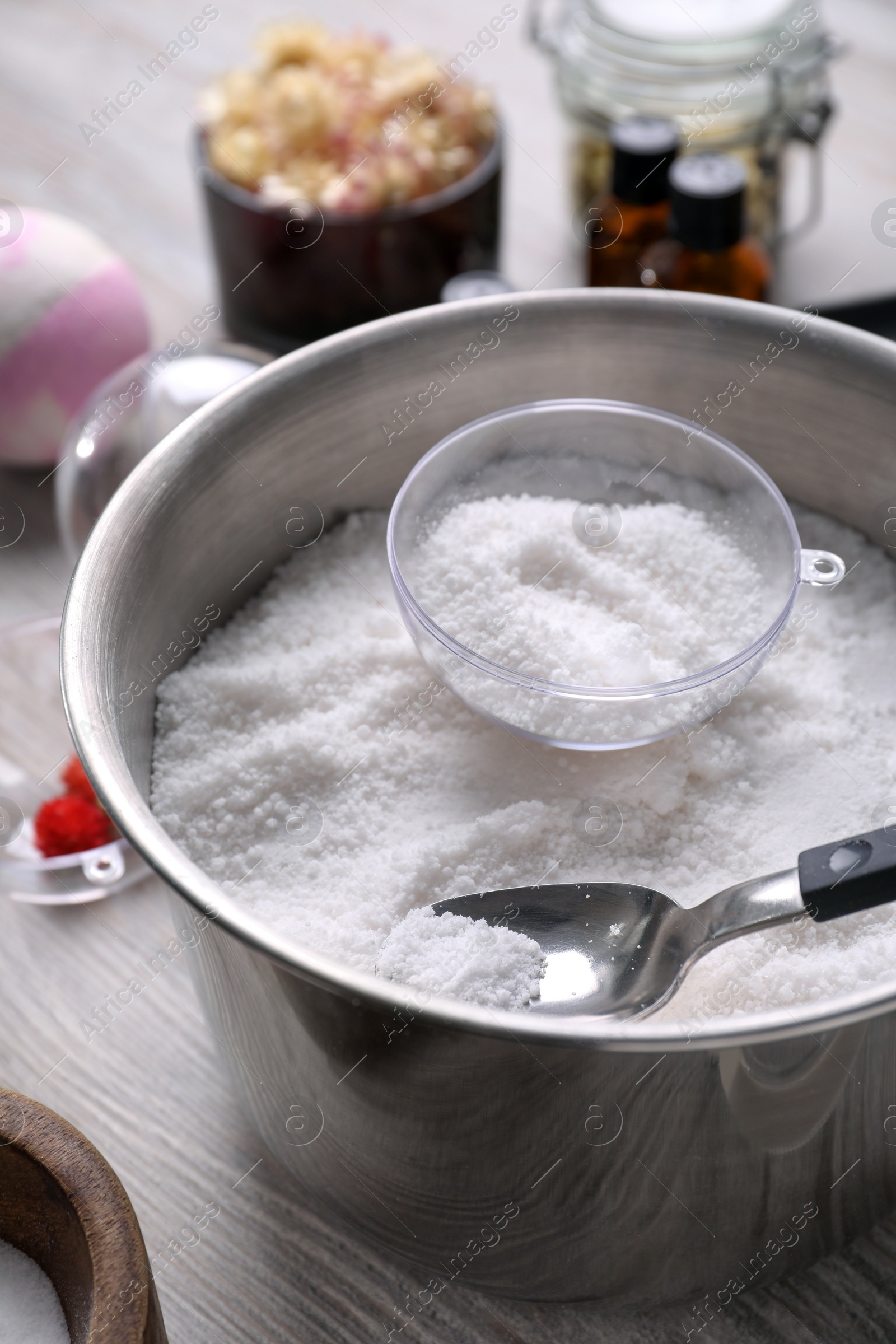 Photo of Metal bowl with bath bomb mixture, mold and spoon on wooden table