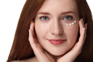 Photo of Beautiful woman with freckles and cream on her face against white background, closeup