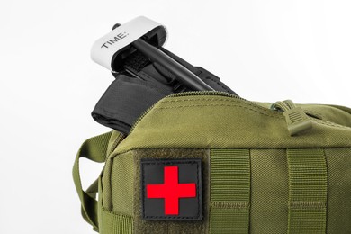 Photo of Military first aid kit and tourniquet isolated on white, closeup