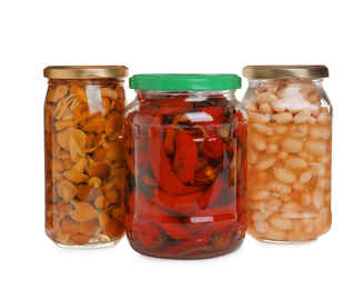 Glass jars of different pickled vegetables isolated on white