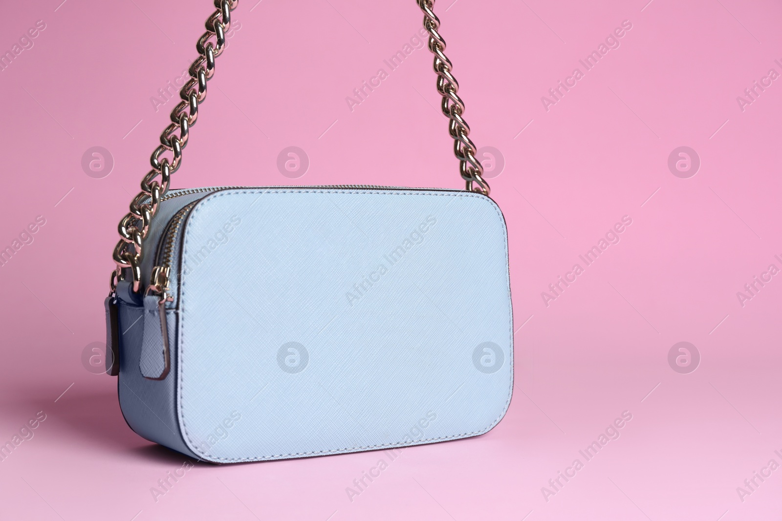 Photo of Stylish woman's bag on light pink background