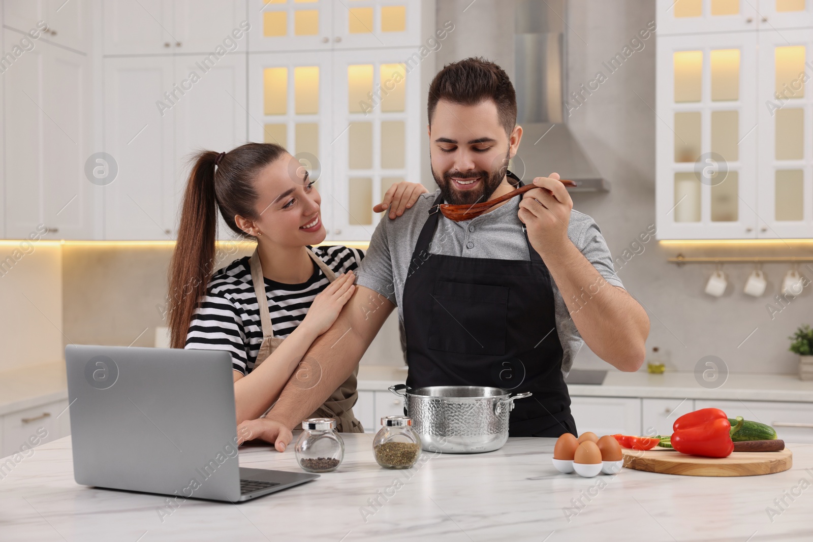 Photo of Lovely young couple cooking together in kitchen