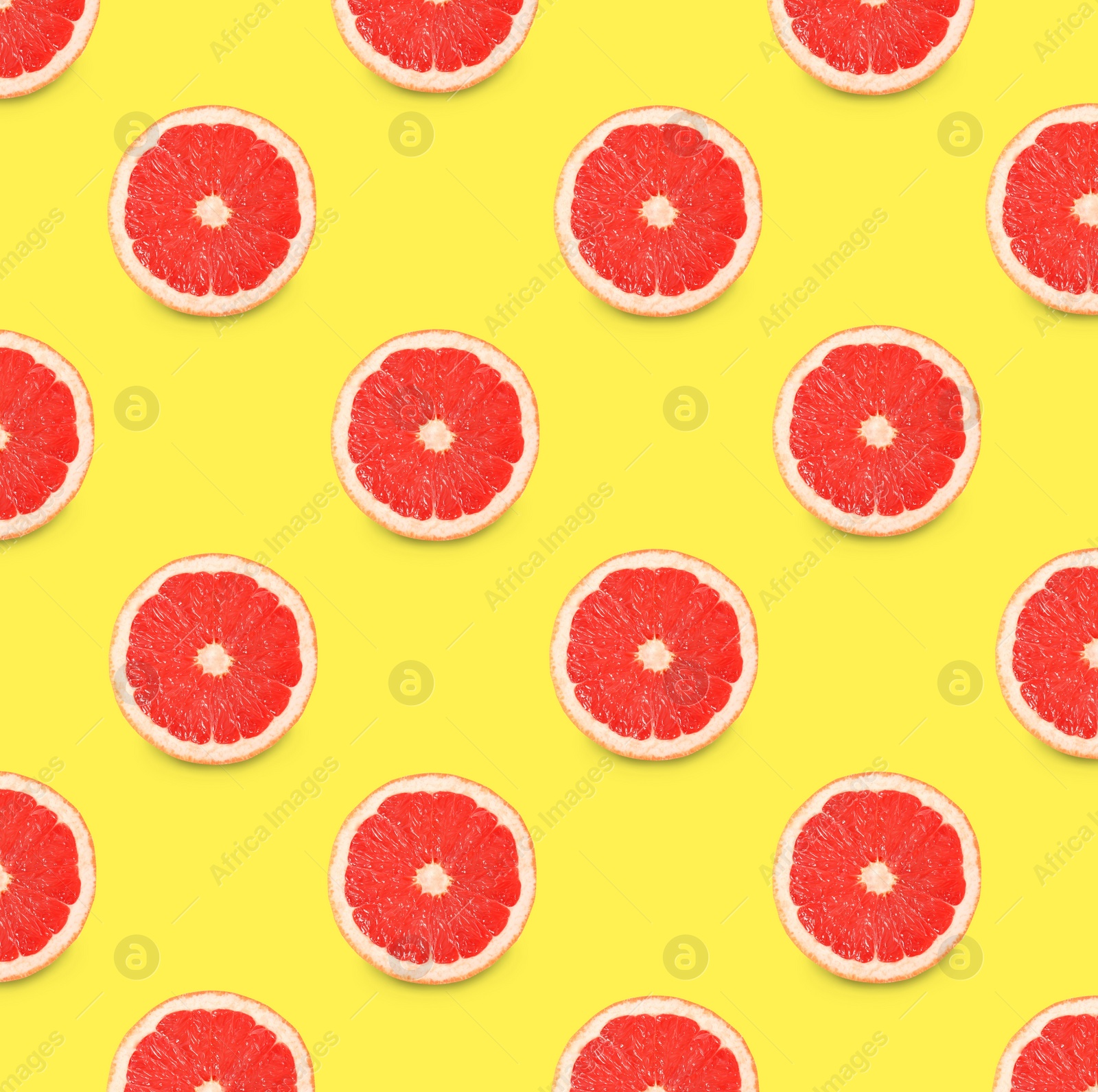 Image of Many fresh ripe slices of grapefruits on yellow background, flat lay. Seamless pattern design