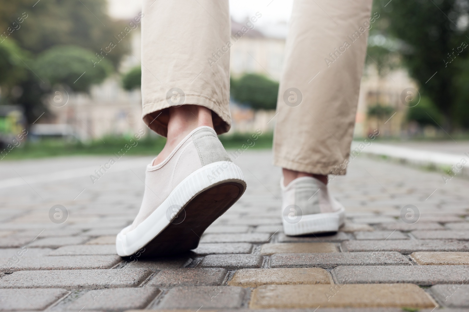 Photo of Man in stylish sneakers walking on city street, closeup