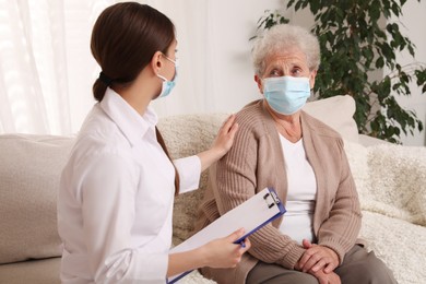 Doctor examining senior woman with protective mask at nursing home