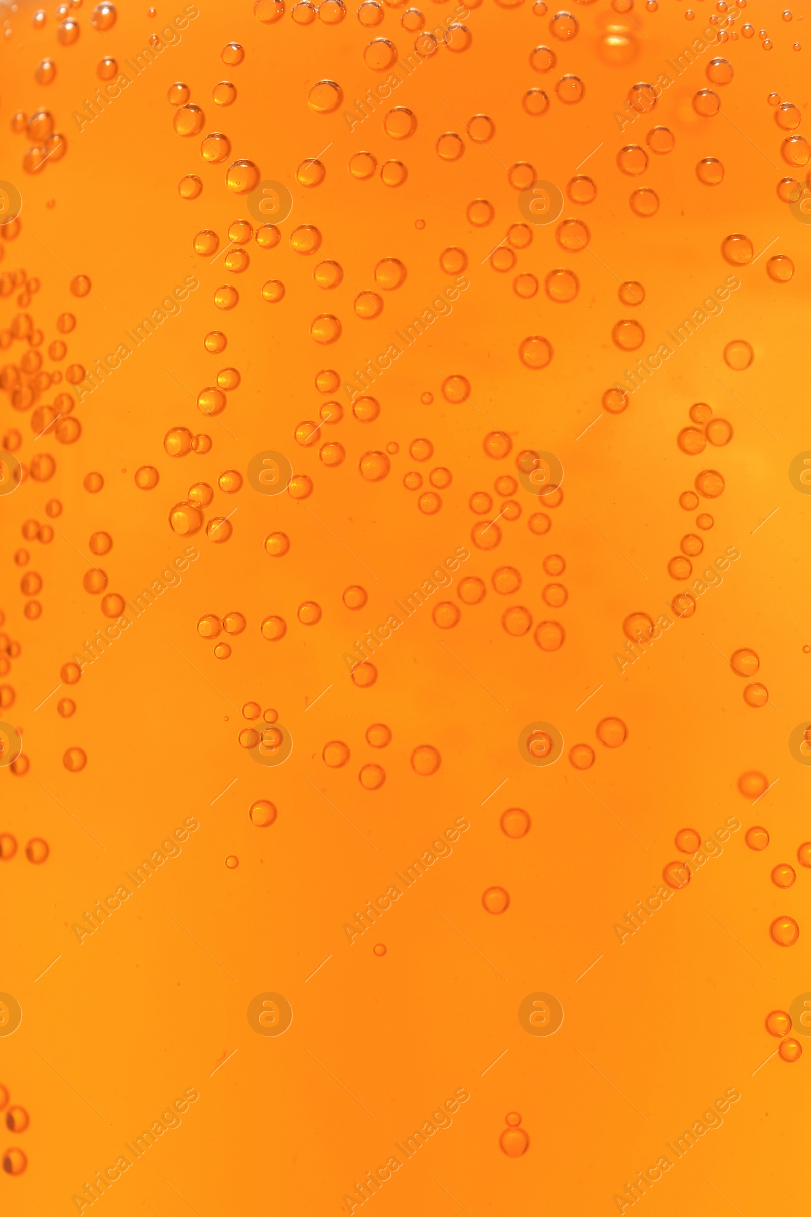 Photo of Orange drink with bubbles as background, closeup