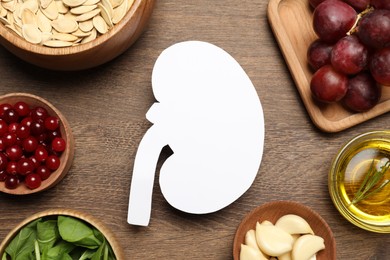 Photo of Flat lay composition with paper cutout of kidney and different products on wooden table