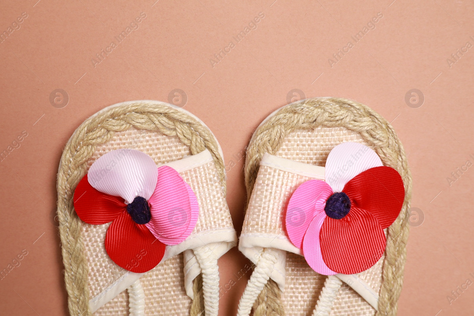 Photo of Cute baby shoes on brown background, flat lay