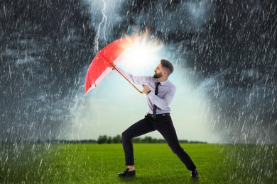 Image of Businessman with umbrella under heavy rain. Insurance concept