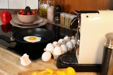 Frying eggs for breakfast in kitchen, selective focus