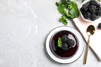 Photo of Delicious jelly with blackberries and mint on grey table, flat lay. Space for text