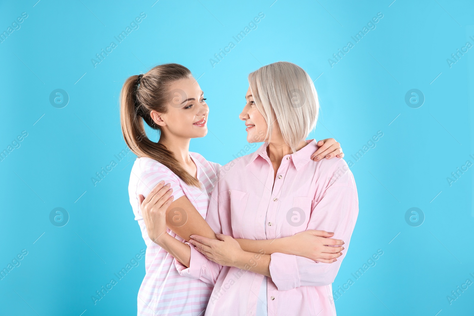 Photo of Portrait of young woman with her mature mother on color background