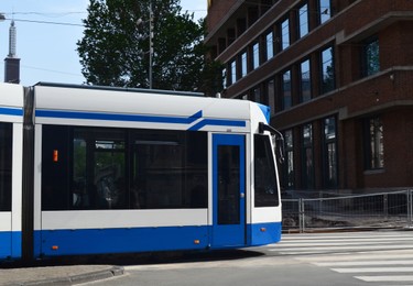 Modern tram on city street with urban architecture