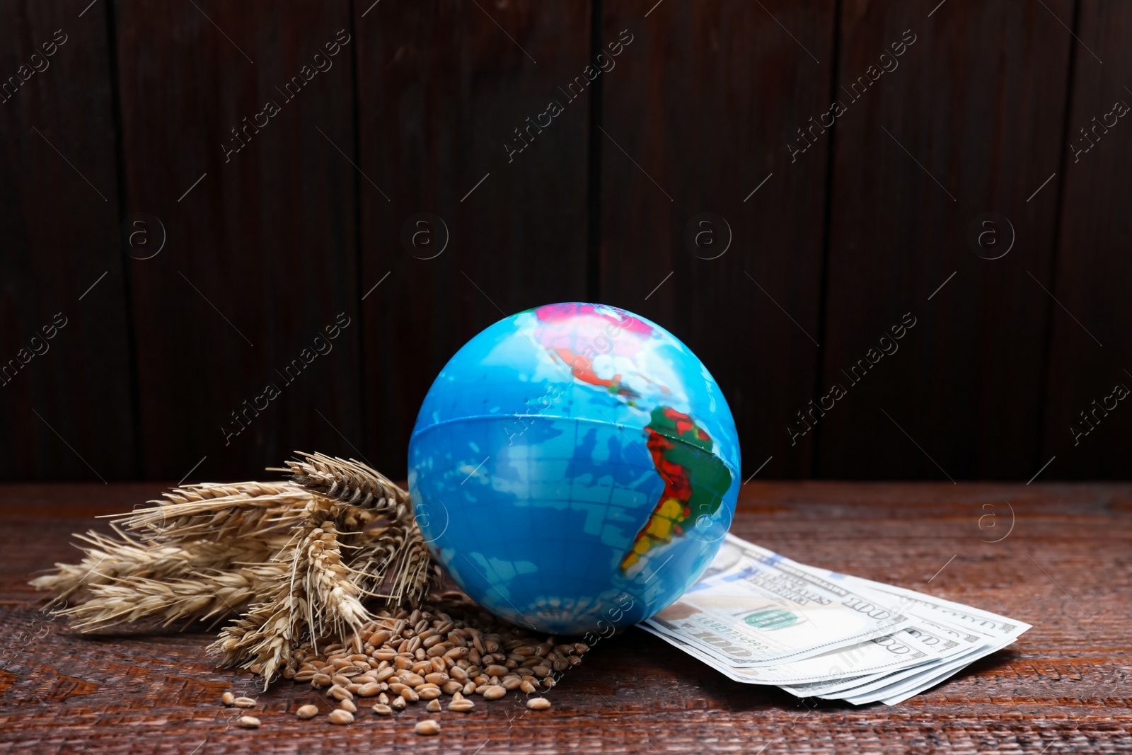 Photo of Globe, ears of wheat and banknotes on wooden table. Import and export concept