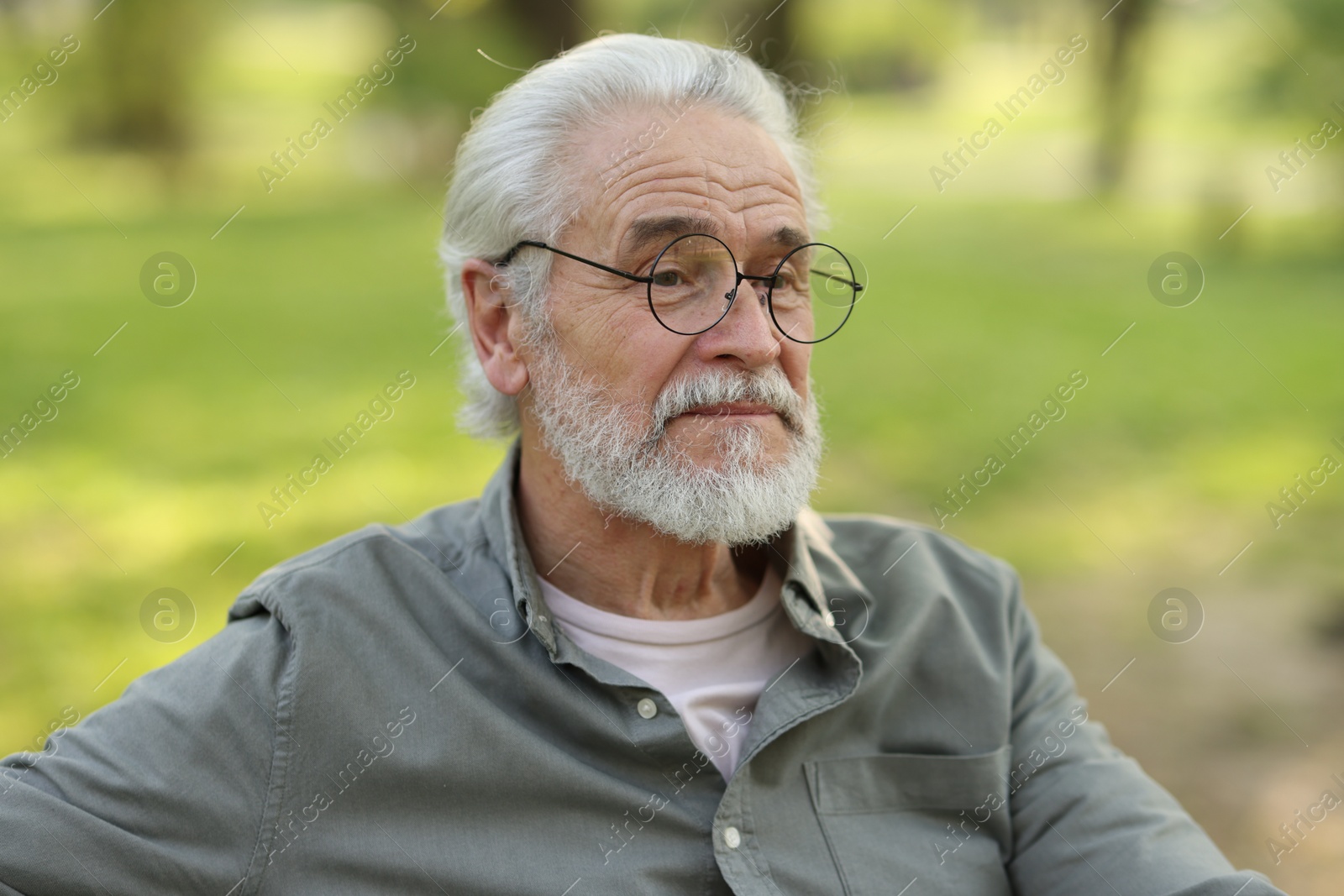 Photo of Portrait of happy grandpa with glasses in park