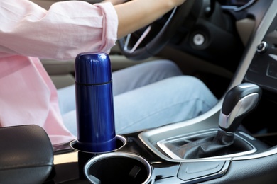 Blue thermos in holder inside of car