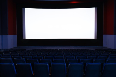 Photo of Empty cinema with large screen and comfortable chairs. Space for text
