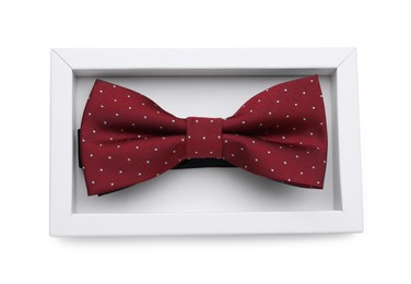 Photo of Stylish burgundy bow tie with polka dot pattern on white background, top view