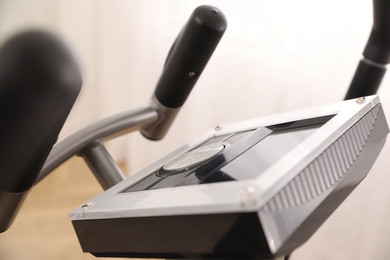 Photo of Control panel of modern elliptical machine cross trainer on blurred background, closeup