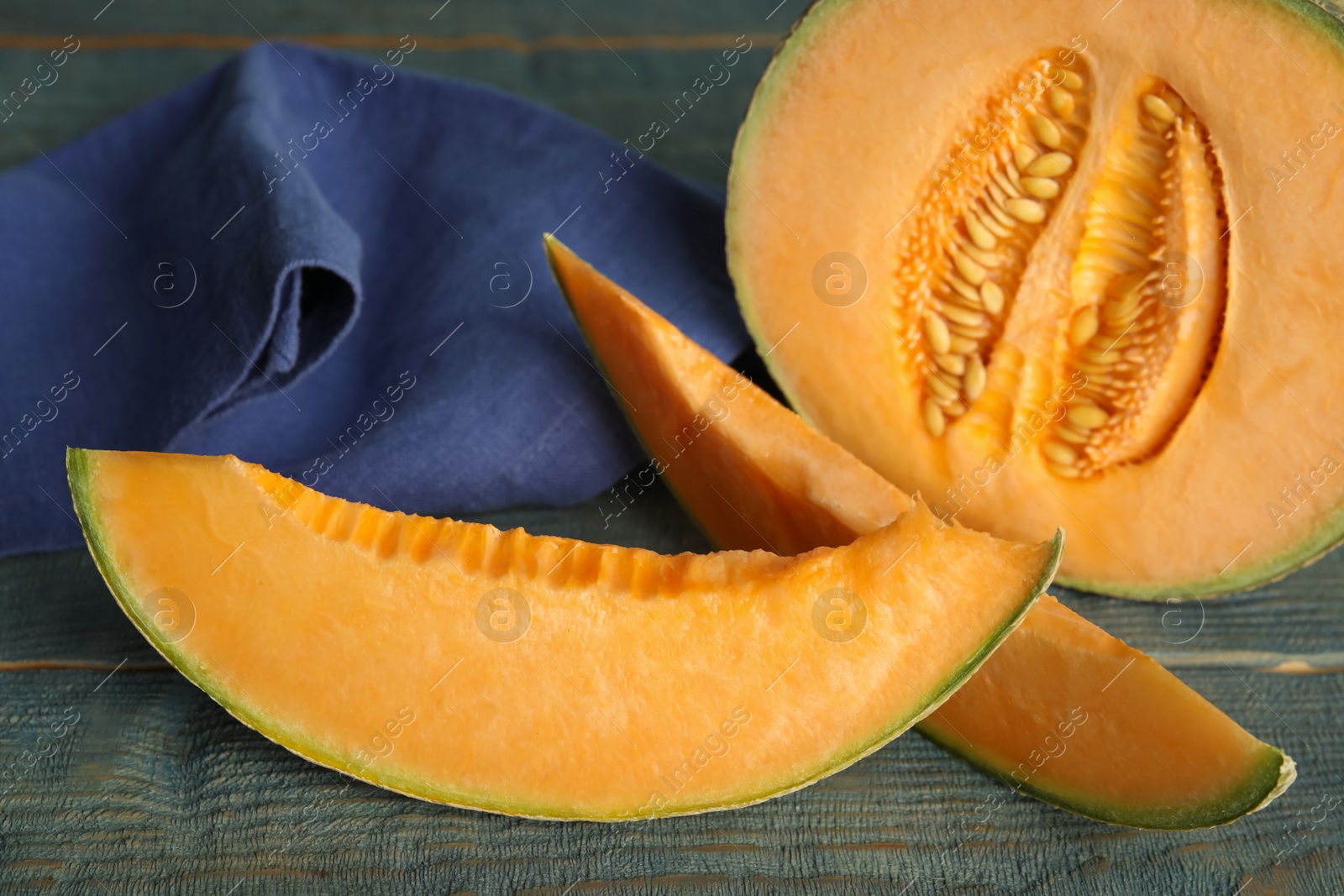 Photo of Tasty fresh cut melon on light blue wooden table, closeup