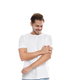 Photo of Young man scratching arm on white background. Annoying itch