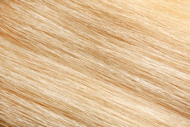 Texture of healthy blond hair as background, closeup