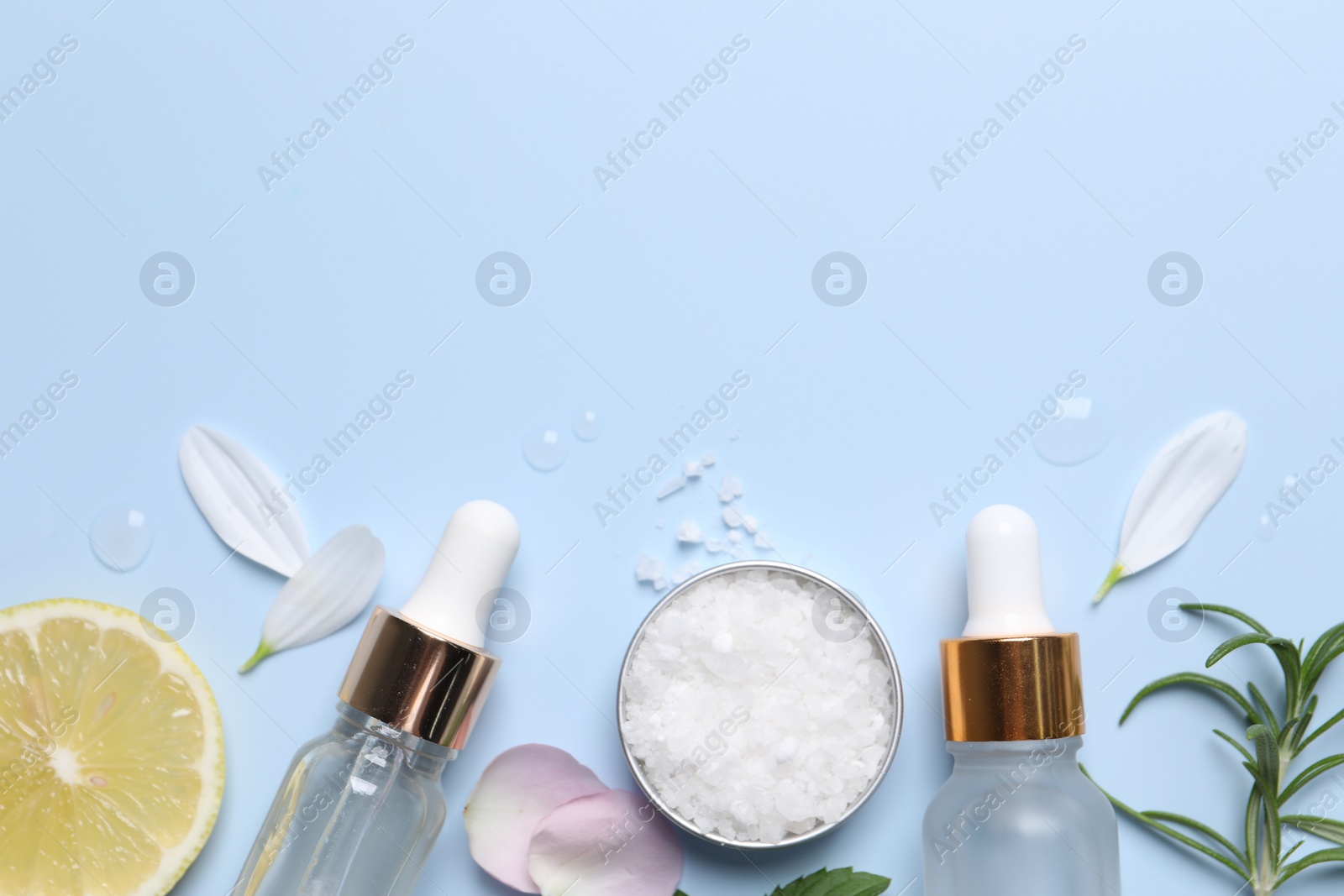 Photo of Flat lay composition with bottles of cosmetic serum on light blue background. Space for text